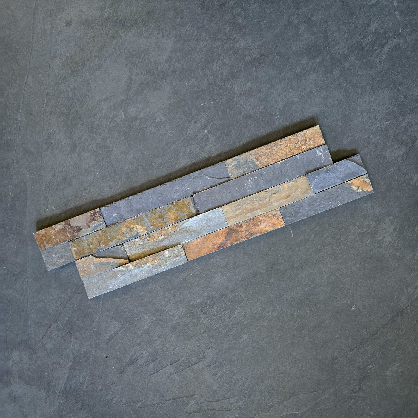 Naturstein Verblender Schiefer Rusty Grey Muster, strukturierte Oberfläche für Wandgestaltung, natürliche graue Farbtöne.