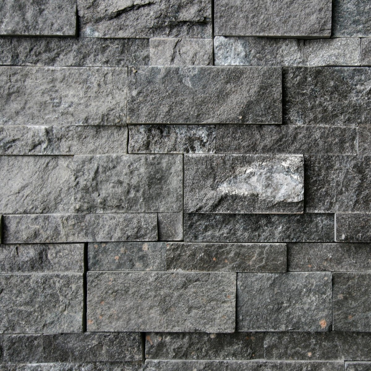 Muster Naturstein Verblender aus Quarzit Karbon Black, strukturierte Oberfläche und dunkle Farbnuancen, ideal für Wandgestaltung.