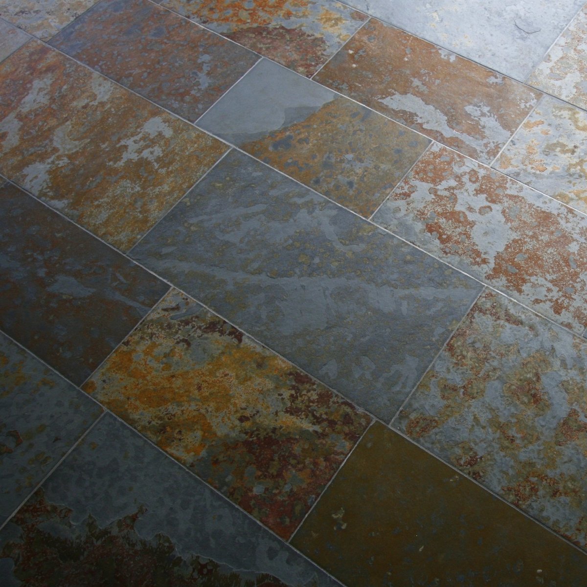 Mehrfarbige Schieferfliesen im Musterstil, von Muster, mit verschiedenen Farbtönen und Texturen, ideal für Wand- oder Bodenbeläge.
