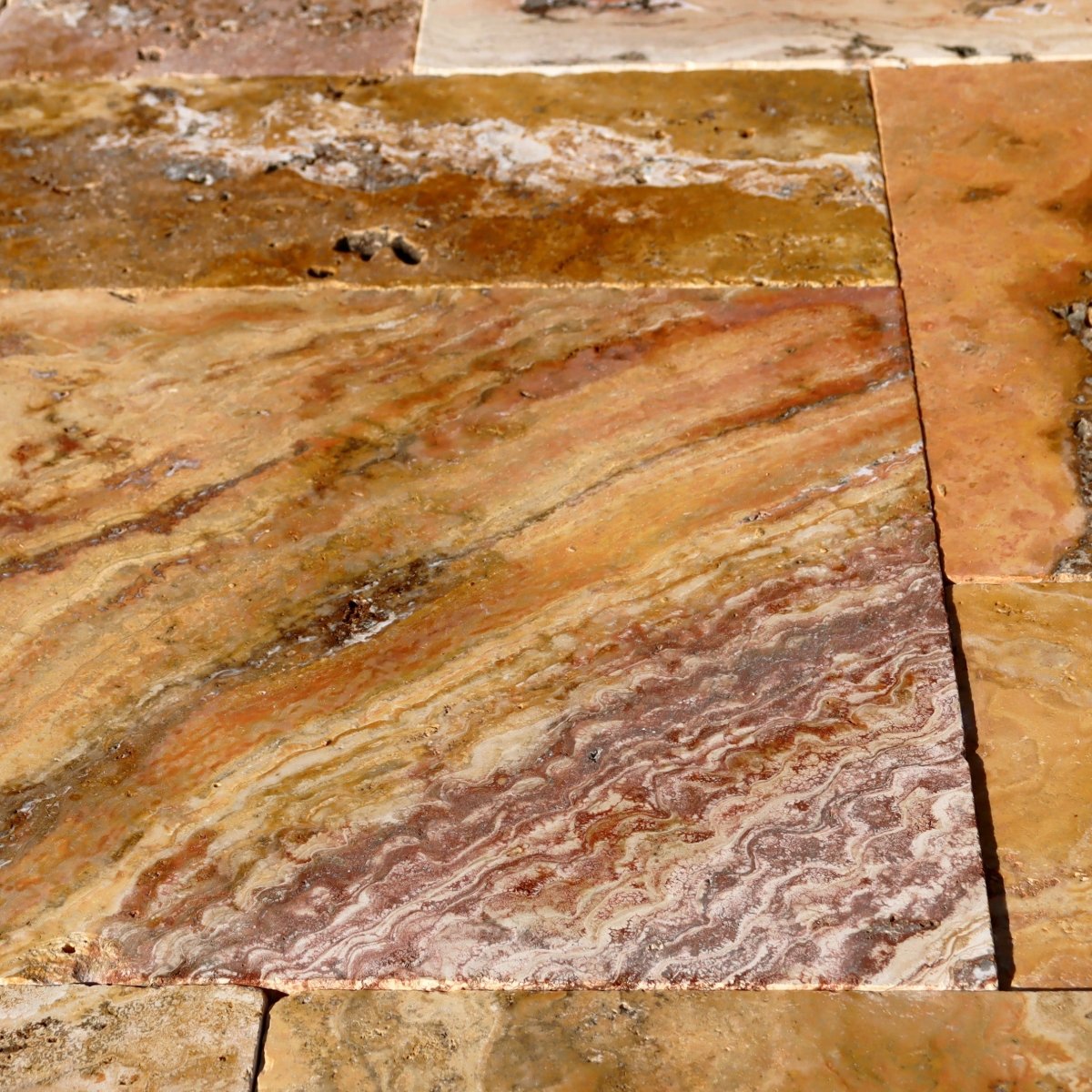 Musterfliese aus getrommeltem Travertin Scabas Antik Gold mit antiker, rustikaler Optik, natürliche Textur und warme Goldtöne.